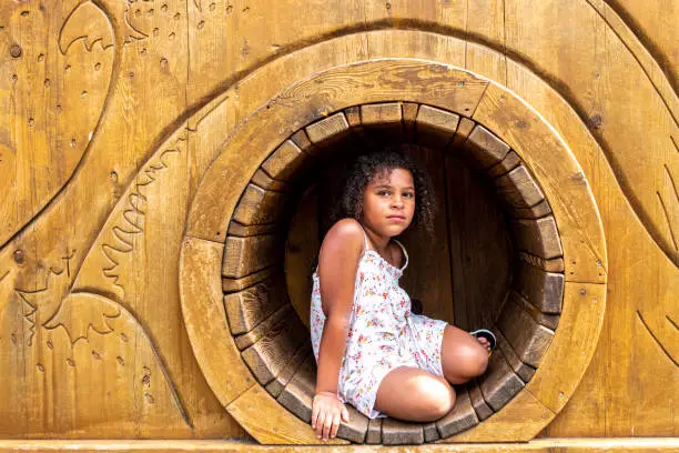 Child sitting in a hide in playground