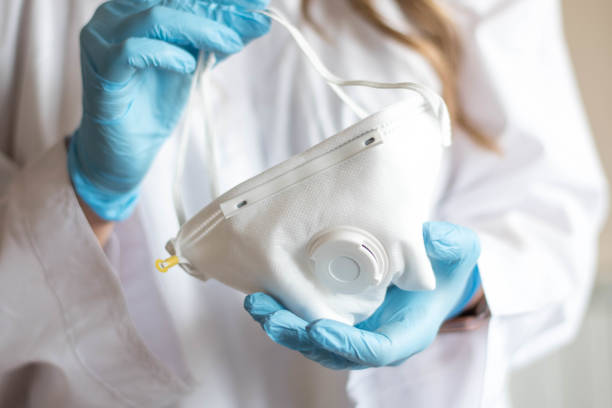 Nurse wearing respirator mask holding a positive blood test stock photo