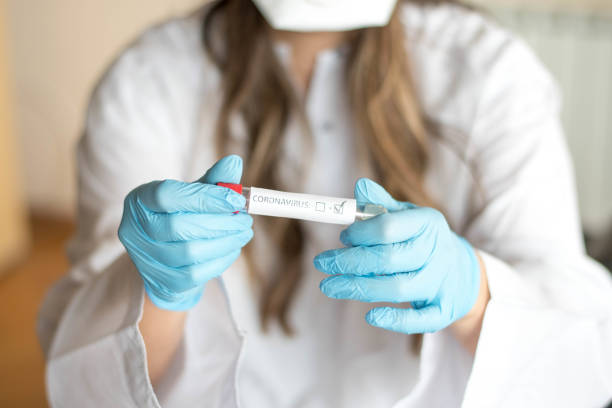 Nurse wearing respirator mask holding a positive blood test stock photo