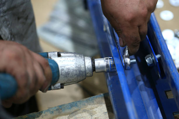 istock One warehouse worker in with power tool tightening screw during rack arrangement erection work 1211211001