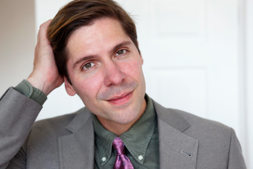 Portrait of a young attractive stylish man in white shirt and red scarf with dots.