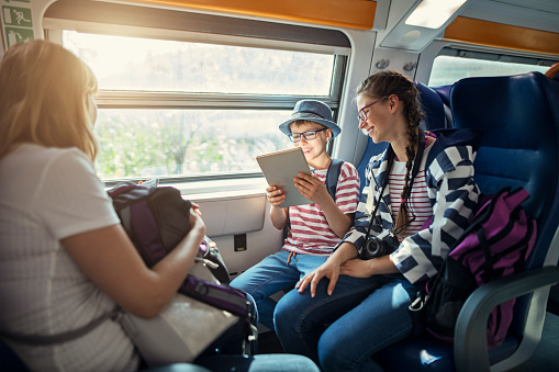 Mother and kids tourists travelling by train between towns of Cinque Terre, Italy. The kids are using digital tablet.
Nikon D850