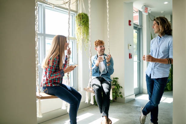 istock Smiling Freelance Workers Enjoying Coffee Break on Swings 1211216381