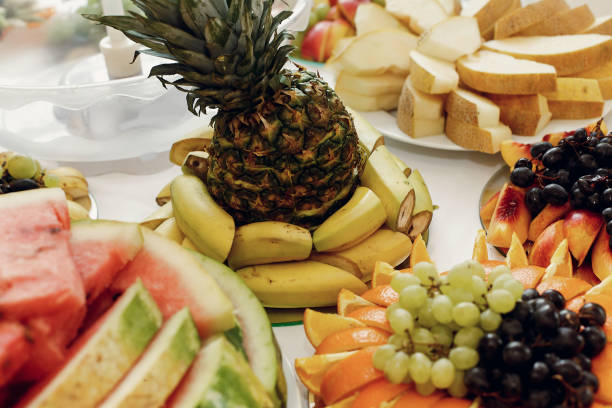 istock delicious pineapple and bananas, grapes and oranges, fruit bar table at wedding reception. catering in restaurant 1211216446
