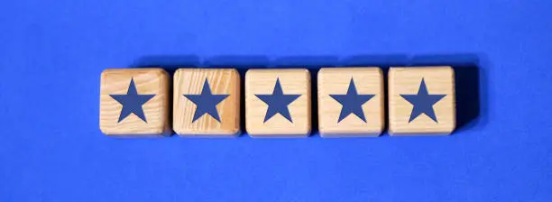 Photo of Best Excellent Services Rating customer experience concept. Wooden blocks with the five star. The best rating, the best ranking, the best service on a blue background
