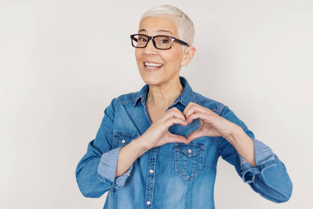 istock Senior Woman makes Romantic Heart Gesture 1211217276