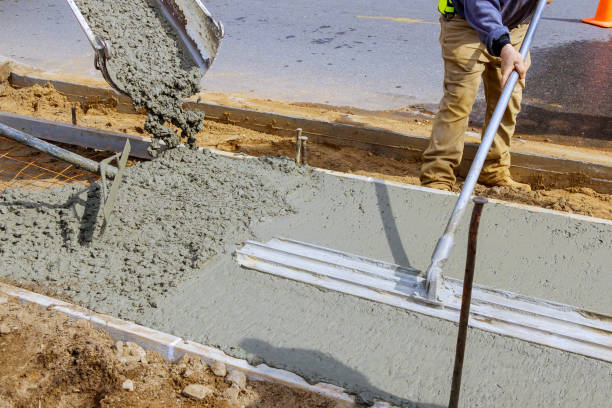 istock Construction worker pour cement for sidewalk in concrete works with mixer truck with wheelbarrow 1211217570