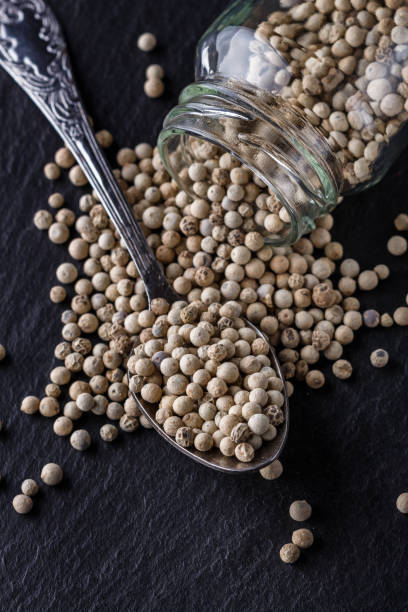istock white peppercorns on dark slate stone background 1211218556