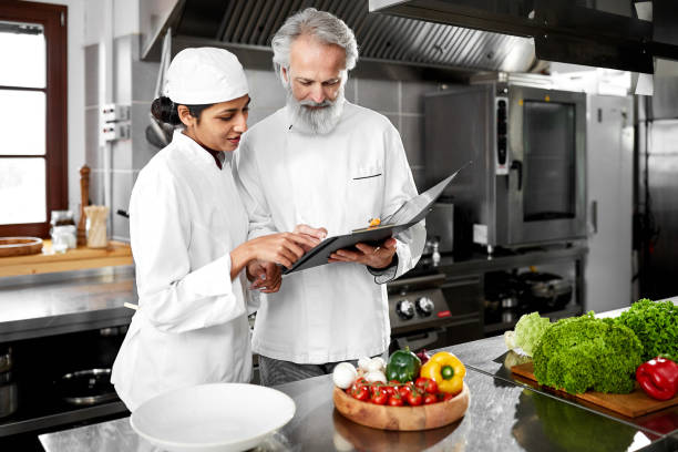 istock Chef and indian sous chef planning in the kitchen 1211218637