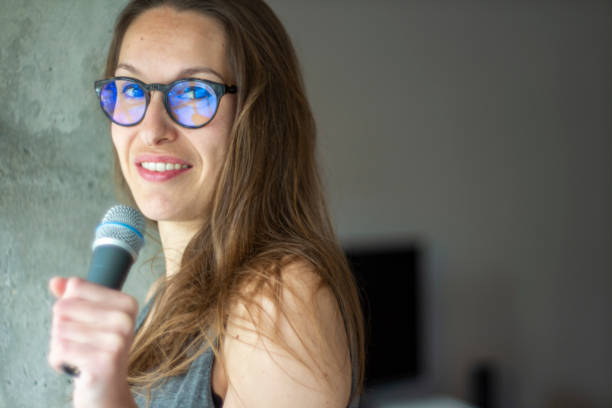 istock Young beatuful woman holding a mic 1211218638