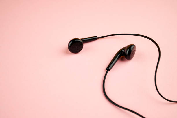 istock black earphone isolated on a pink pastel backdrop. flat lay. outer space. music minimalism concept 1211218939