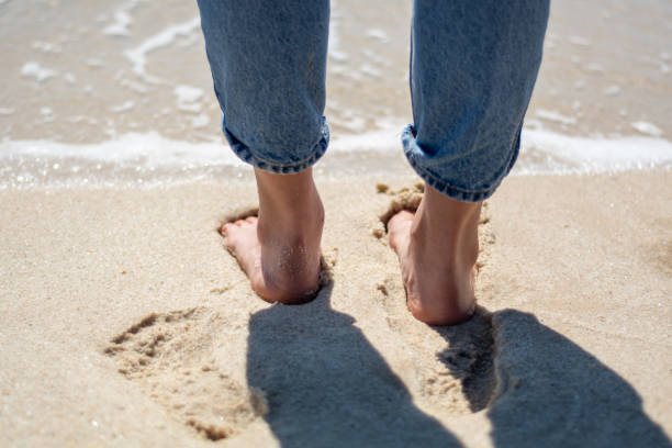 zbliżenie stóp chodzących po piasku na plaży w dżinsach - 4604 zdjęcia i obrazy z banku zdjęć