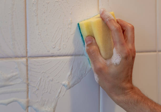 istock Hand cleaning white tiles with scourer 1211227829