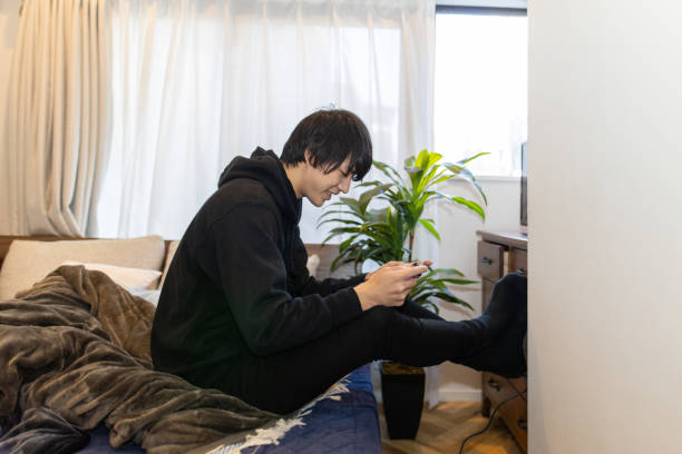 istock Young man playing video games in his room 1211228788