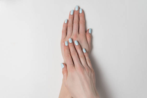 istock Blue manicure on short nails. Hands on white background. Salon 1211229912
