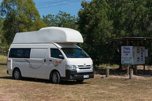 Northern Territory, Australia - June 2, 2019: White motorhome, campervan vehicle parked at information sign at Fogg Dam. Tourism Northern Territory, Australia