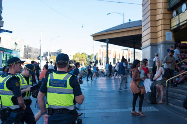 Police officers on duty near Flinders station in Melbourne at ruch hour Melbourne, Australia - December 7, 2016: Police officers on duty near Flinders station in Melbourne at rush hour with crowds of people entering the station melbourne street crowd stock pictures, royalty-free photos & images