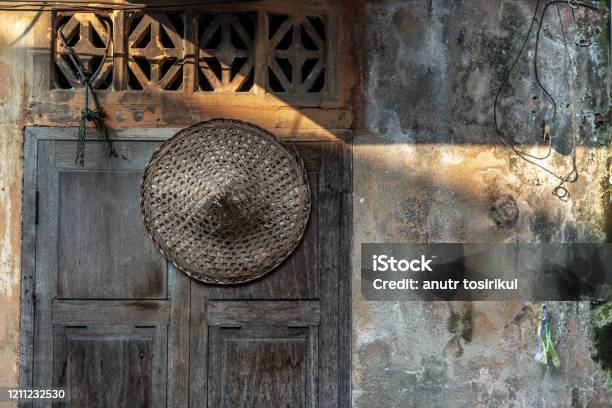 Chinese Straw Hat Hung On The Old Wooden Windows That Are Closed Stock Photo - Download Image Now
