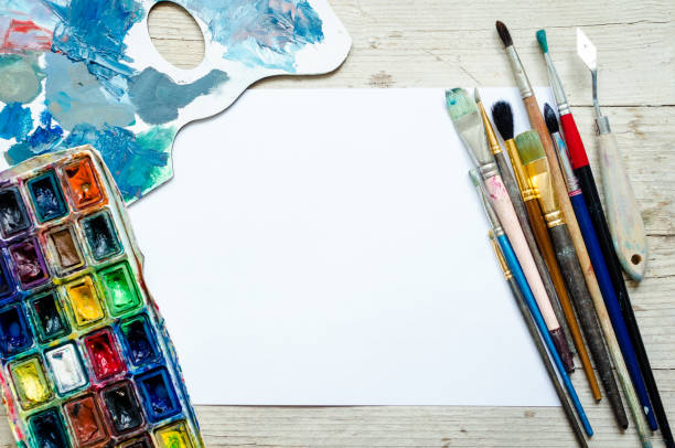 istock Artist paint brushes on the wooden background 1211232695