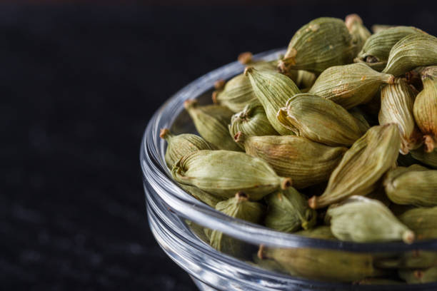 Cardamoms in glass jars on a black table
