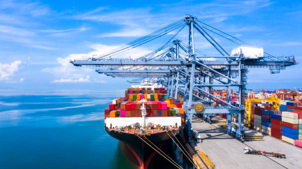 istock Aerial view container cargo ship freight shipping unloading at original destination port with quay crane, Business commercial global oversea logistic import export container box by container vessel . 1211239979