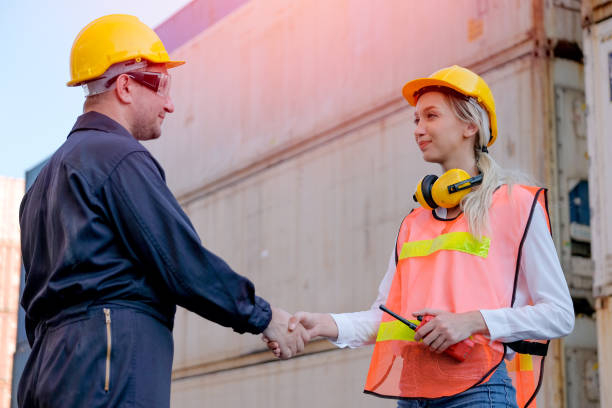 istock Technician man and woman shake hand together in front of cargo container with concept of successful in shipping business 1211244991