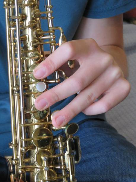 istock teen boy's hands playing saxophone close-up 1211245957