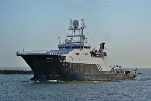 The research vessel R/V petrel passes the Jetty at Cape Canaveral, Florida. The vessel is equipped to deploy remotely operated deep sea vehicles aka ROVs, The ship specializes in exploring sunken ships, especially those of historical or military importance. It is owned by Microsoft cofounder Paul Allen