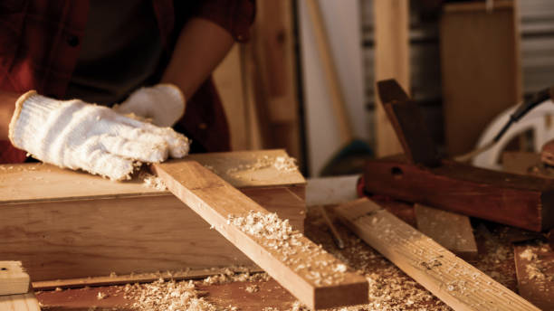 istock Carpenter holding pieces of board at site. 1211247282