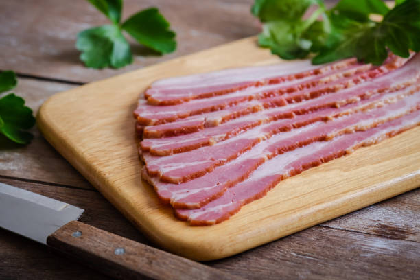 istock Raw sliced bacon on wooden board 1211247413