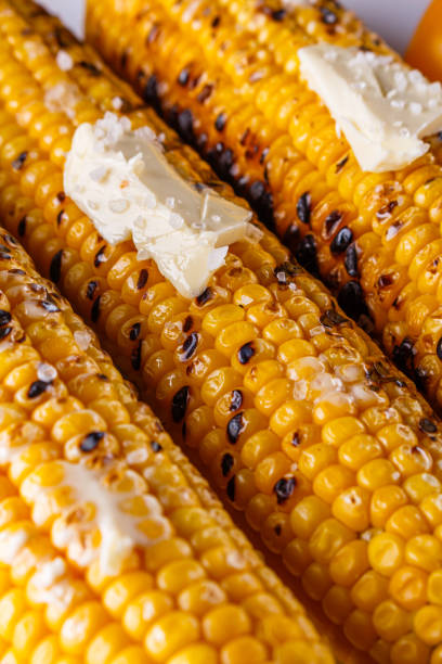 espiga de milho grelhado em fundo rústico de madeira branca - corn corn on the cob grilled roasted - fotografias e filmes do acervo
