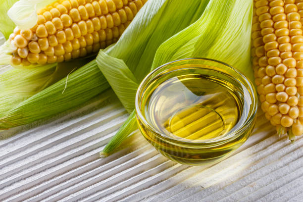 istock corn oil on white wooden rustic background 1211249024
