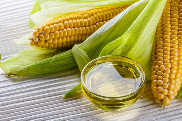 istock corn oil on white wooden rustic background 1211249056