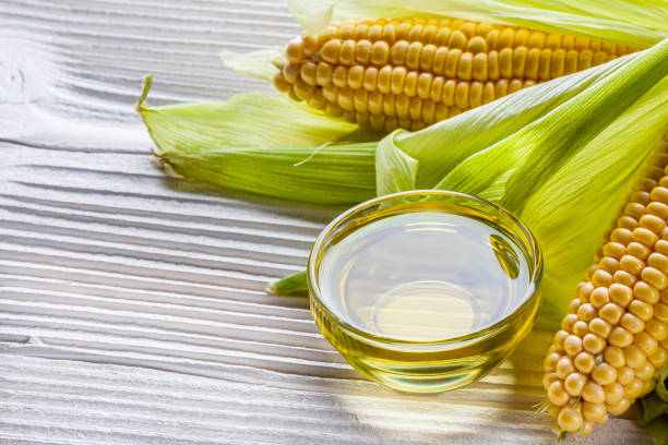 istock corn oil on white wooden rustic background 1211249080