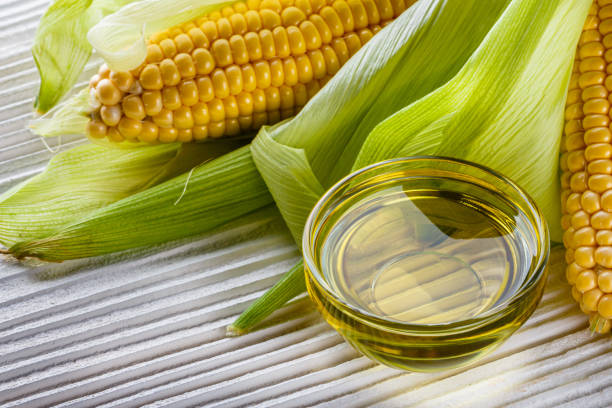 istock corn oil on white wooden rustic background 1211249120