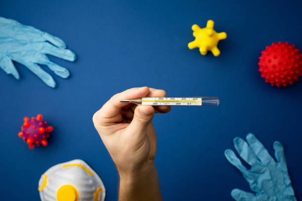 istock Hand with medical thermometer virus concept model. 1211249954