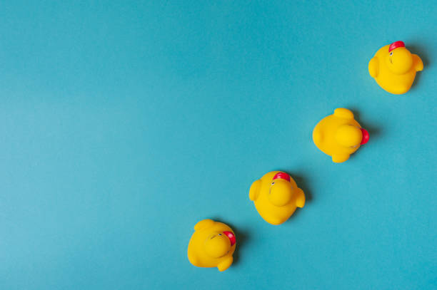 istock Four yellow rubber ducks on a blue background. Bath concept. Copy space, flat lay. 1211251845