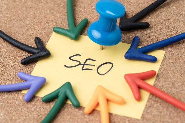istock SEO Search Engine Optimization, keywords marketing to drive traffic to website concept, Thumbtack pushpin with multi arrows pointing to small paper note written the word SEO 1211255691