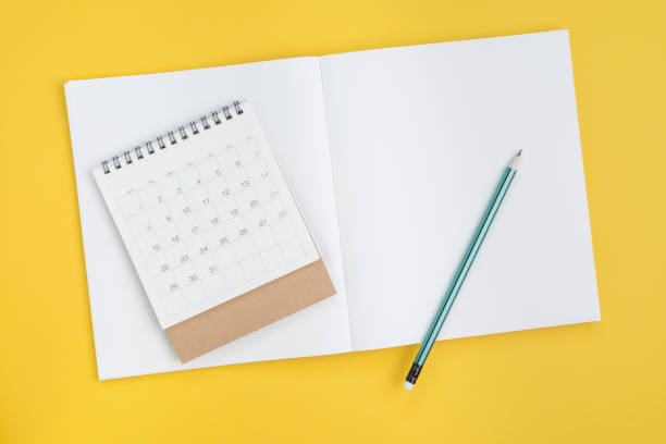 Timeline planning, checklist or business plan with calendar date concept, pencil on blank page note book paper with calendar on yellow background