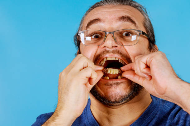 istock Man's hand putting dental crowns in teeth 1211256509