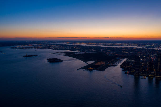 ligne d’horizon de ville de jersey et paysage urbain de new york dans le coucher du soleil - new jersey industrial district newark harbor photos et images de collection