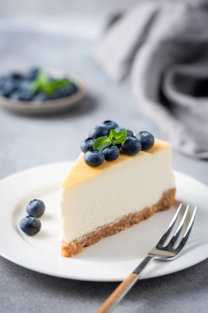 Cheesecake slice with fresh blueberries Cheesecake slice with fresh blueberries on white plate, vertical orientation deli pie stock pictures, royalty-free photos & images