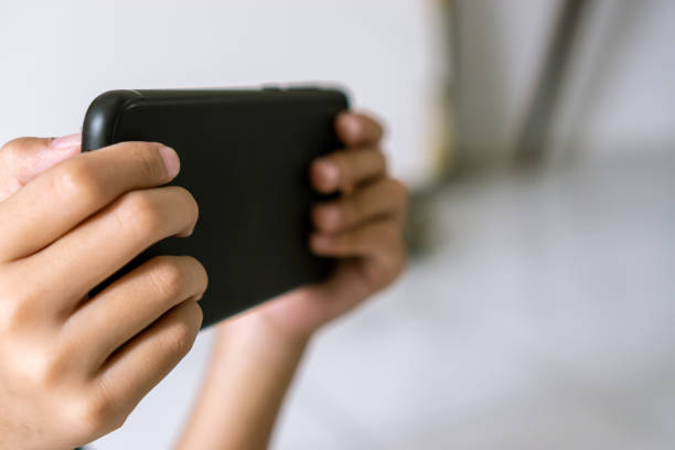 istock Close up kids hand play smartphone 1211259349