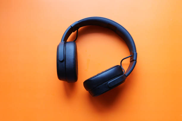 istock top view of black color headphone on orange table 1211270477