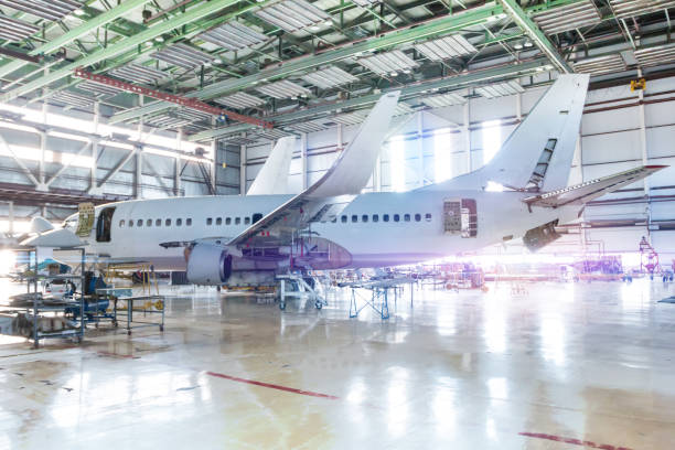 istock White passenger aircraft in the hangar. Airplane under maintenance. Checking mechanical systems for flight operations 1211270494