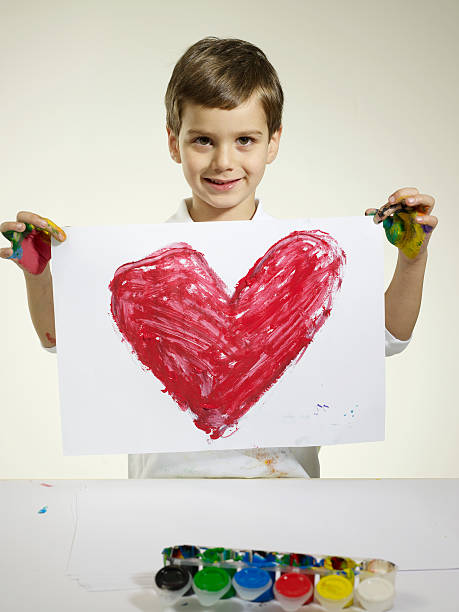 Love Little artist holding picture. cute boy show love symbol hand stock pictures, royalty-free photos & images