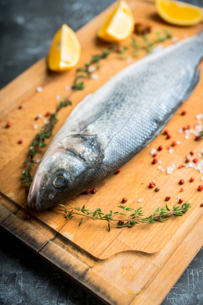 istock Raw whole seabass fish on the rustic background 1211273758