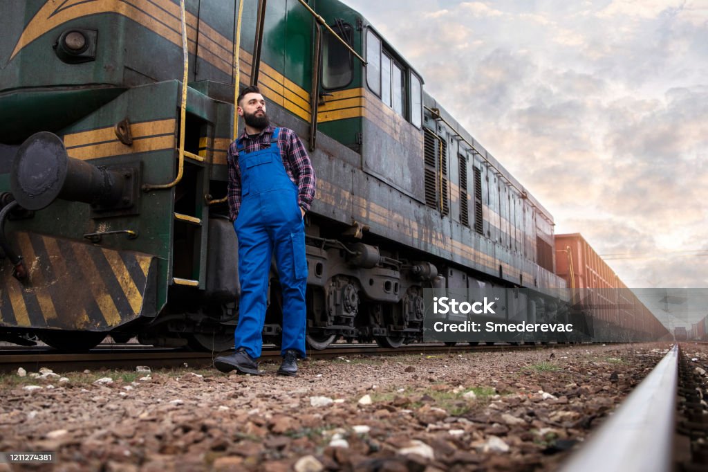 Engine Driver Standing By Freight Train With Cargo Container Trailers In  Background Stock Photo - Download Image Now - iStock