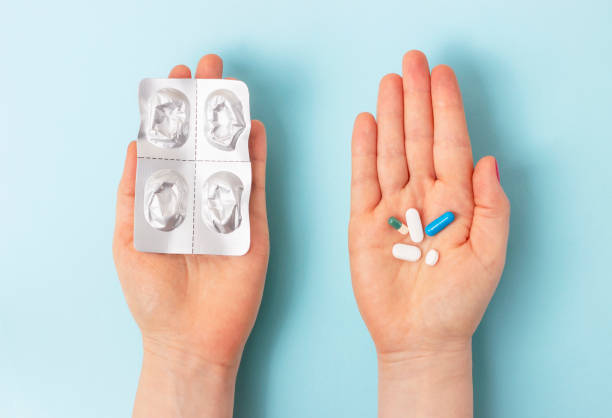 istock Female hands hold a blister and pills on blue background top view. 1211274639