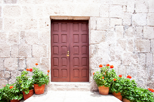 Entrance door to the house, on the sides of the stairs with pots of flowers in monastery Saint Catalina, Arequipa, Peru